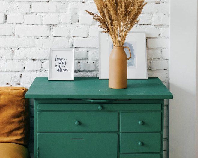 Simple, elegant interior deign with a shelf, pictures and a plant